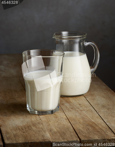 Image of milk jug and glass on wooden table