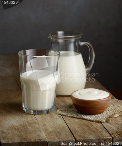 Image of milk and sour cream on wooden table