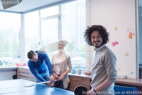 Image of startup business team playing ping pong tennis