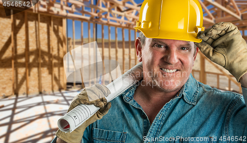 Image of Smiling Contractor in Hard Hat Holding Floor Plans At Constructi