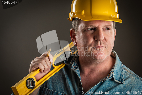 Image of Serious Contractor in Hard Hat Holding Level and Pencil With Dra