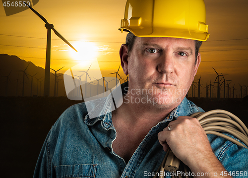 Image of Serious Contractor in Hard Hat Holding Extention Cord Outdoors N