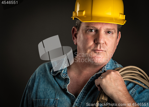 Image of Serious Contractor in Hard Hat Holding Extention Cord With Drama