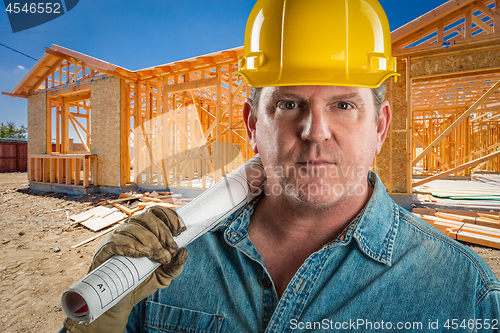 Image of Serious Contractor in Hard Hat Holding Floor Plans At Constructi