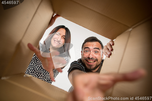 Image of The couple unpacking and opening carton box and looking inside