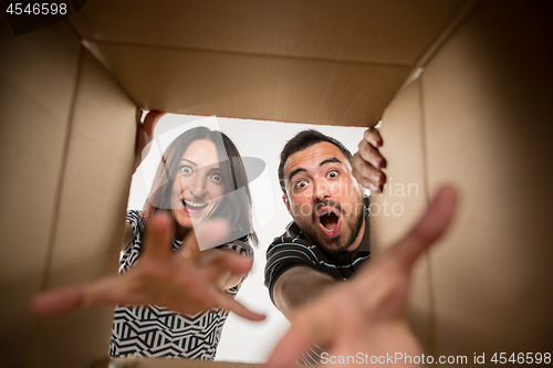 Image of The couple unpacking and opening carton box and looking inside