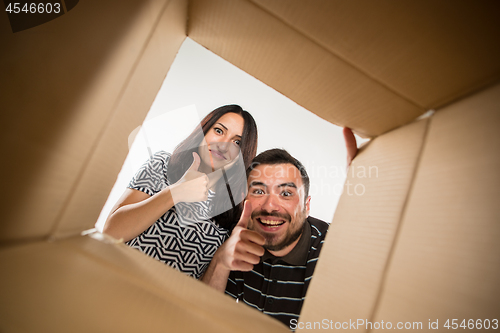 Image of The couple unpacking and opening carton box and looking inside