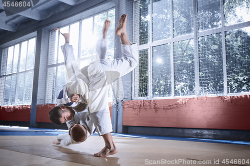 Image of Two judo fighters showing technical skill while practicing martial arts in a fight club