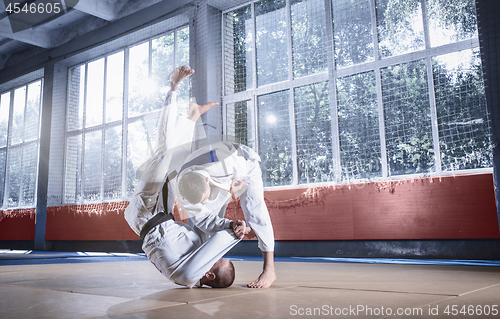 Image of Two judo fighters showing technical skill while practicing martial arts in a fight club