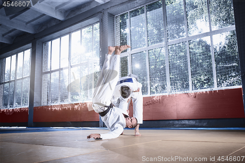 Image of Two judo fighters showing technical skill while practicing martial arts in a fight club