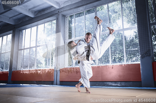 Image of Two judo fighters showing technical skill while practicing martial arts in a fight club