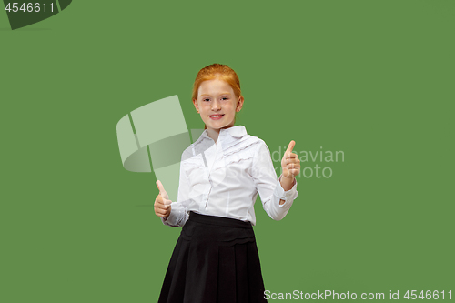 Image of The happy teen girl standing and smiling against p green background.