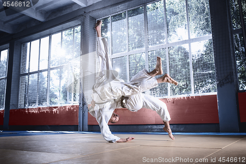 Image of Two judo fighters showing technical skill while practicing martial arts in a fight club