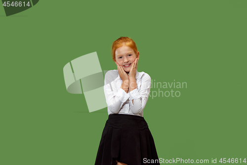 Image of The happy teen girl standing and smiling against green background.