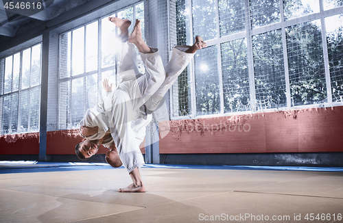 Image of Two judo fighters showing technical skill while practicing martial arts in a fight club