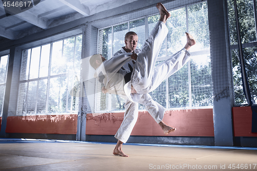 Image of Two judo fighters showing technical skill while practicing martial arts in a fight club