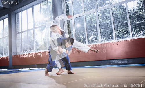 Image of Two judo fighters showing technical skill while practicing martial arts in a fight club