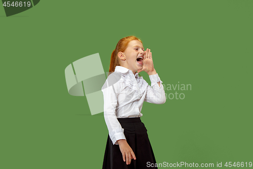 Image of Isolated on green young casual teen girl shouting at studio