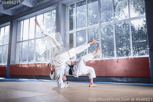 Image of Two judo fighters showing technical skill while practicing martial arts in a fight club