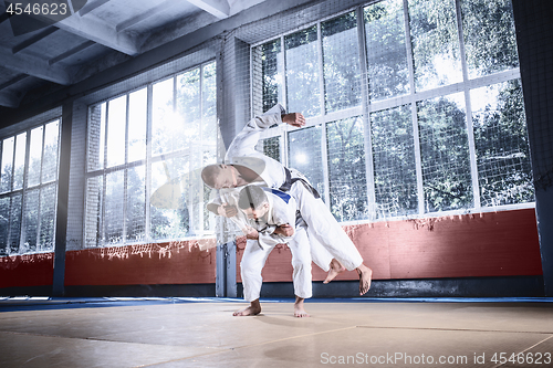 Image of Two judo fighters showing technical skill while practicing martial arts in a fight club