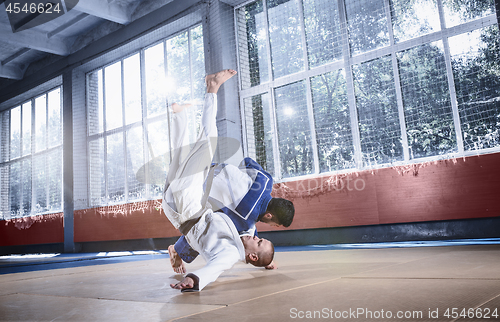 Image of Two judo fighters showing technical skill while practicing martial arts in a fight club