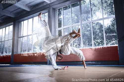 Image of Two judo fighters showing technical skill while practicing martial arts in a fight club