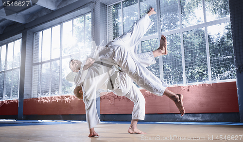 Image of Two judo fighters showing technical skill while practicing martial arts in a fight club