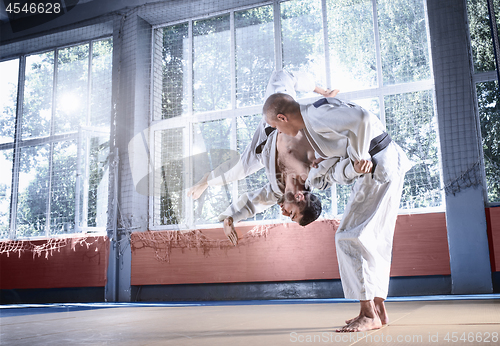 Image of Two judo fighters showing technical skill while practicing martial arts in a fight club