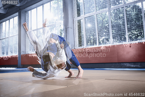 Image of Two judo fighters showing technical skill while practicing martial arts in a fight club