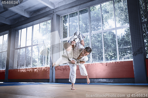 Image of Two judo fighters showing technical skill while practicing martial arts in a fight club