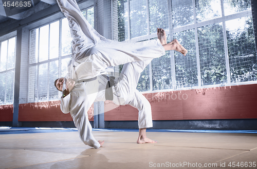 Image of Two judo fighters showing technical skill while practicing martial arts in a fight club