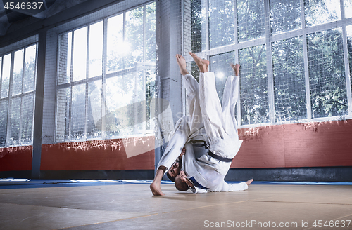 Image of Two judo fighters showing technical skill while practicing martial arts in a fight club