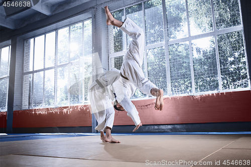 Image of Two judo fighters showing technical skill while practicing martial arts in a fight club