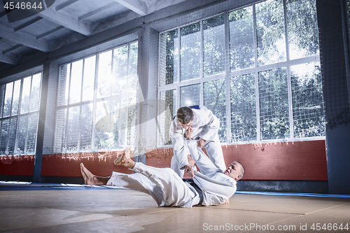 Image of Two judo fighters showing technical skill while practicing martial arts in a fight club