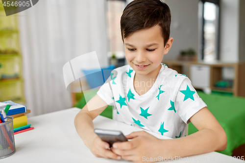 Image of happy boy with smartphone at home