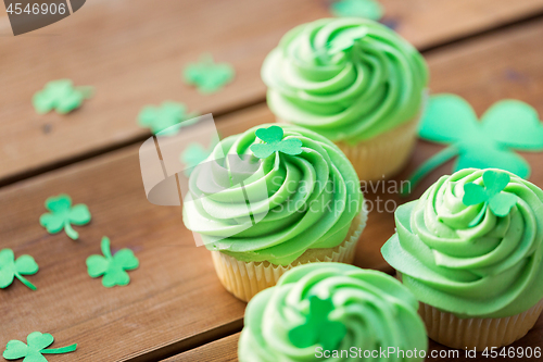 Image of green cupcakes and shamrock on wooden table