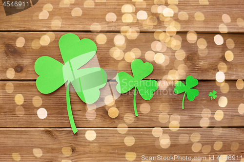 Image of green paper shamrocks on wooden background