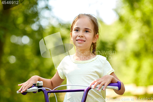 Image of happy little girl with bicycle in summer