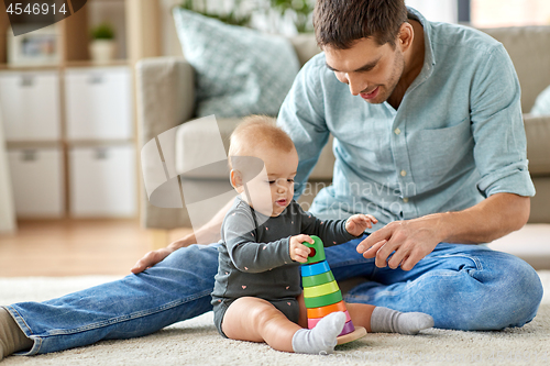 Image of father playing with little baby daughter at home