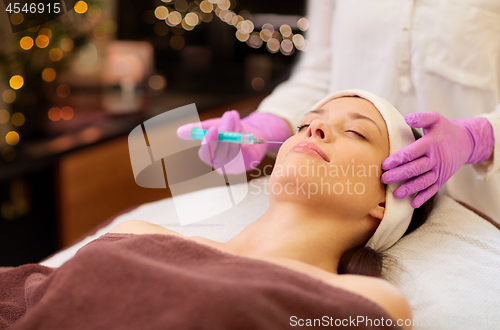 Image of beautician doing beauty injection to woman lips