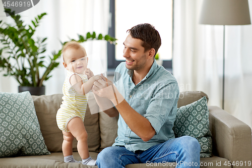 Image of father with little baby daughter at home