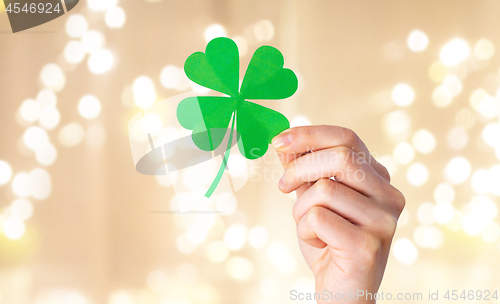 Image of hand holding green paper four-leaf clover
