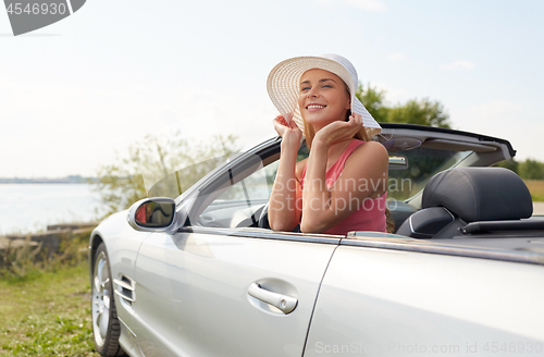 Image of happy young woman in convertible car