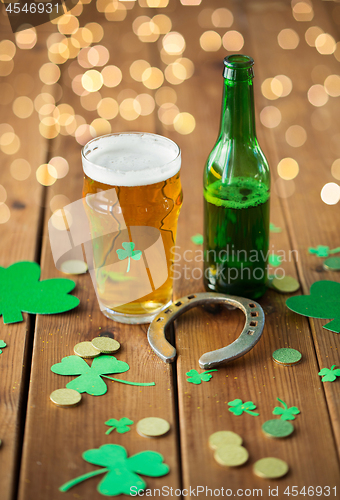 Image of glass of beer, bottle, horseshoe and gold coins