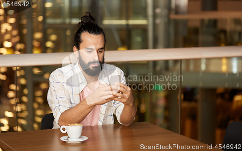 Image of man with coffee and smartphone at restaurant