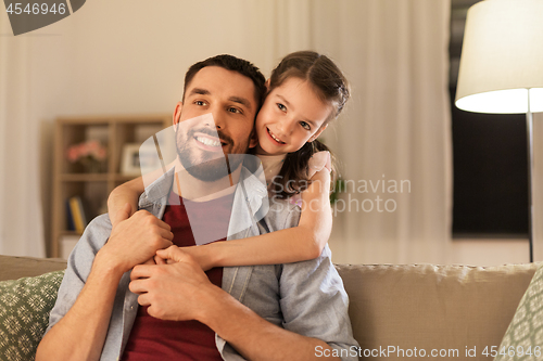 Image of happy father and little daughter hugging at home