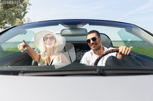 Image of happy man and woman driving in cabriolet car