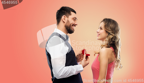 Image of man giving woman engagement ring on valentines day