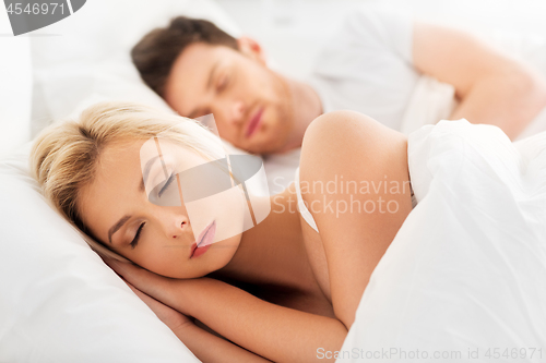 Image of happy couple sleeping in bed at home