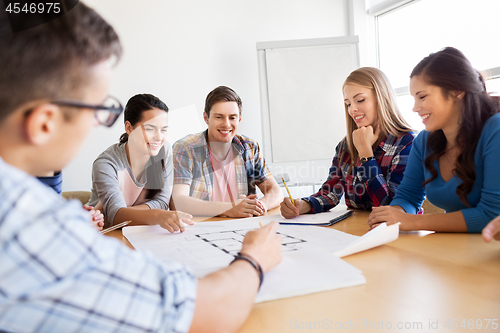 Image of group of smiling students with blueprint